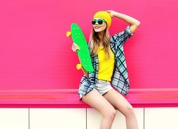 Cool smiling woman with skateboard wearing colorful yellow hat o — Stock Photo, Image