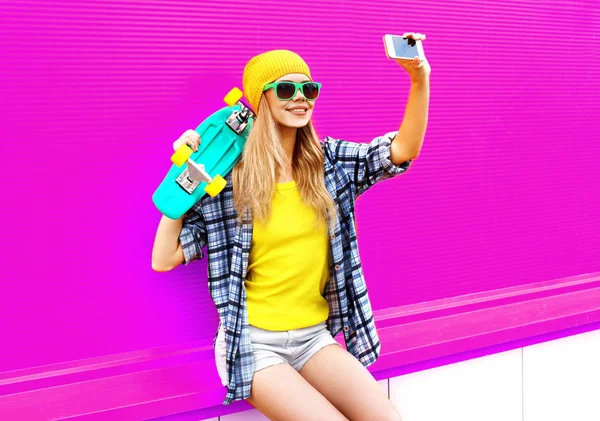 Cool uśmiechnięta kobieta robi zdjęcie selfie przez smartfona ze skatem — Zdjęcie stockowe