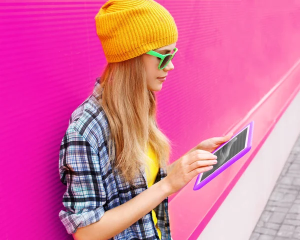 Retrato jovem mulher usando tablet pc usando chapéu amarelo colorido — Fotografia de Stock