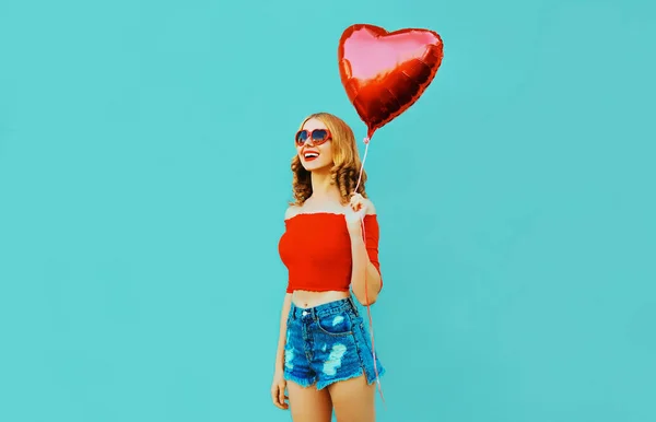 pretty happy smiling woman walking with red heart shaped air bal