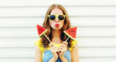 Dondurma şekilli suyla kırmızı dudaklar üfleyen genç bir kadın portresi.