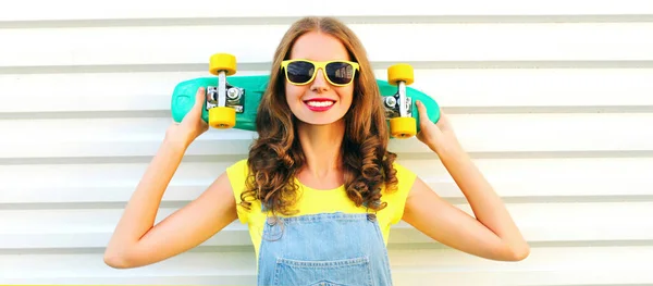 Ritratto giovane donna sorridente con skateboard sopra backgrou bianco — Foto Stock