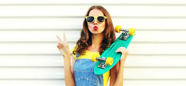 Portrait cool young woman with skateboard over white background — 스톡 사진