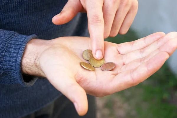 若い男の手を閉じると ウクライナのトリフル 鉄の硬貨のお金をカウントします 若い専門家のための小さな給与の概念 — ストック写真
