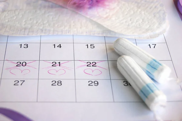 紫丁香背景月经期日历上的月经垫和卫生棉条 — 图库照片