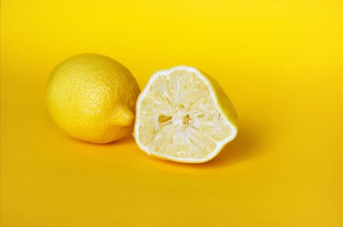 Sarı arka planda izole edilmiş taze limonlar..