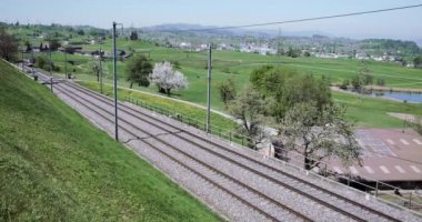 SAMSTAGERN, SWitzERLAND - 22 Nisan 2020: Wadenswil ve Einsiedeln arasında bir yolcu treni Samstagern çevresindeki pitoresk İsviçre kırsalında çalışır..