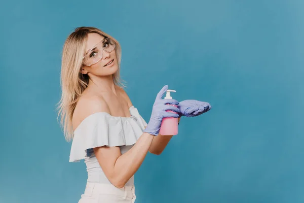 Charming Blonde Protective Glasses Gloves Squeezes Out Sanitizer Her Hand — Stock Photo, Image