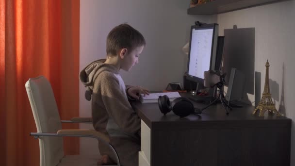 El adolescente está estudiando a distancia. Se sienta en la computadora y estudia en línea. Cuarentena 2020 . — Vídeo de stock