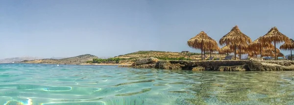 Isla en el Mediterráneo, con paraguas de caña, en océano turquesa — Foto de Stock