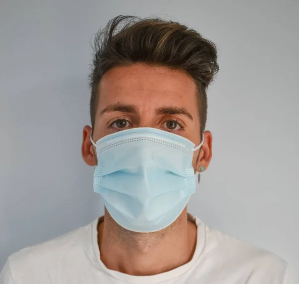 Face of a man with surgical mask in quarantine in his own home, coronavirus