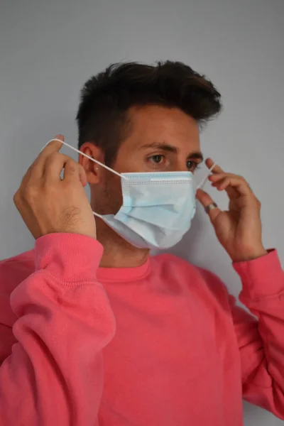 Face of a man with surgical mask in quarantine in his own home, coronavirus