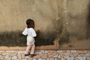 Casamance, Senegal, Ocak 2020: Senegalli kız verandasında çıplak ayakla yürüyor.