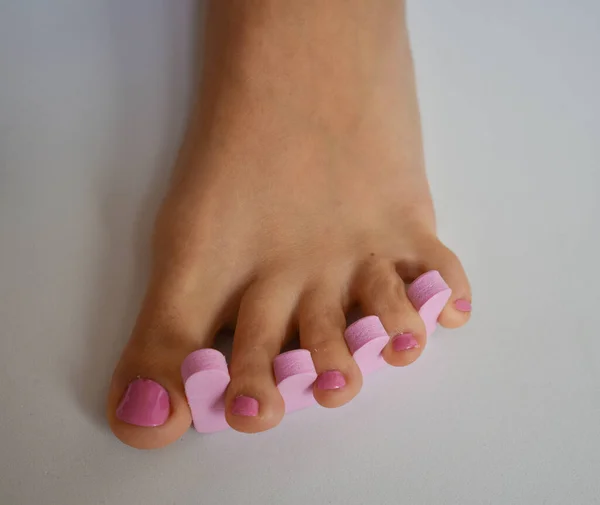 Piede Femminile Con Una Pedicure Mettendo Smalto Rosa Sulle Unghie — Foto Stock