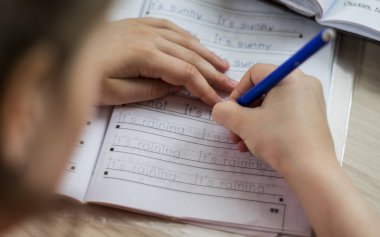 Bir öğrenci evde uzak mesafe yazmayı öğrenir çocuklar için öğrenir.