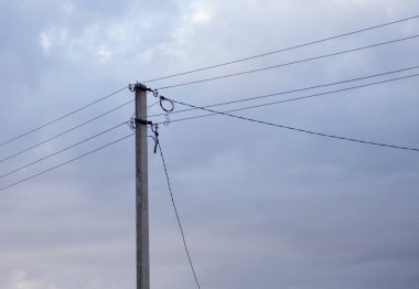 Gökyüzüne karşı izole edilmiş elektrik kabloları olan bir elektrik direği. Güç hattı, güç kaynağı
