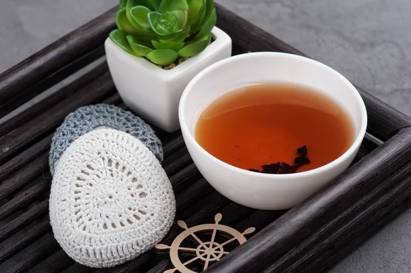 Tasse schwarzen Tee und gehäkelte Kieselsteine — Stockfoto