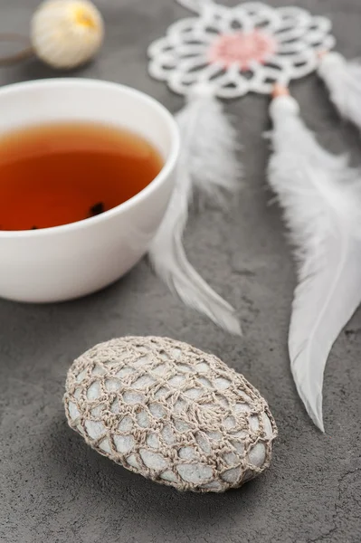 Tasse Tee und gehäkelte Kieselsteine — Stockfoto