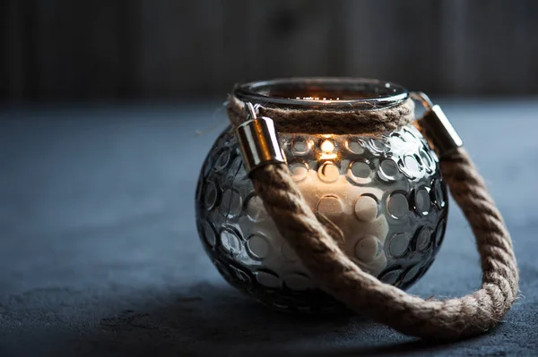 Lanterna com uma vela acesa no fundo de concreto — Fotografia de Stock