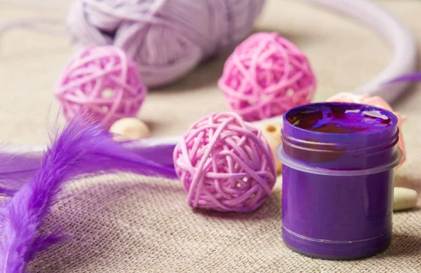 Purple paint, wooden beads, feathers — Stock Photo, Image