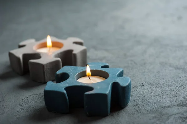 Candlesticks with burning candles on stone background — Stock Photo, Image