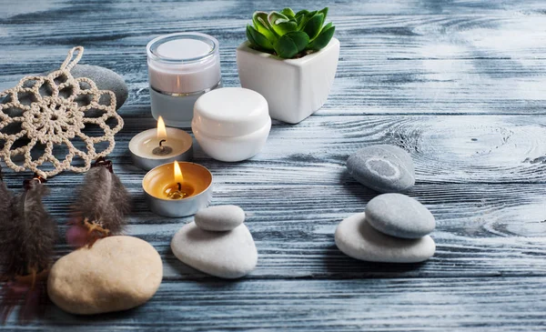 Wellness-Hintergrund mit Kosmetikflaschen, Steinen und brennenden Kerzen — Stockfoto