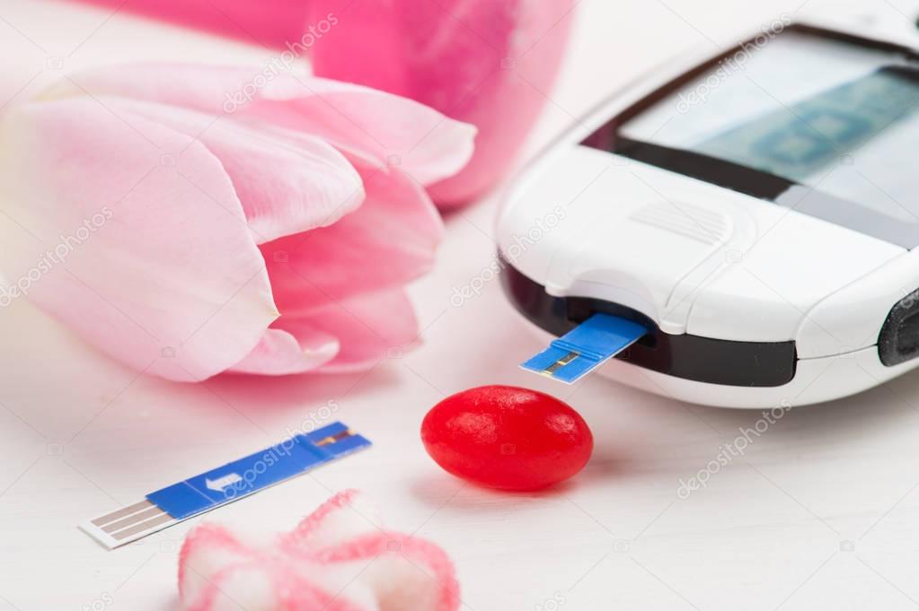Pink dumbbell, sweets and glucose meter