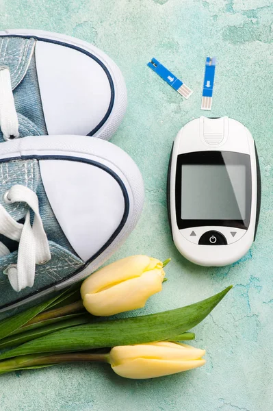 Glucose meter, gumshoes and tulips — Stock Photo, Image