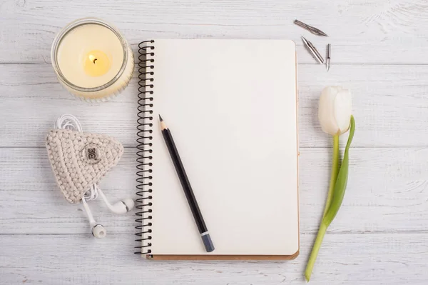 Cuaderno abierto, lápiz, vela, auriculares y tulipán — Foto de Stock
