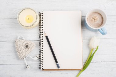 Açık defter, kalem, mum, earpods ve Lale