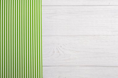 Ahşap masa üzerinde yeşil çizgili masa örtüsü