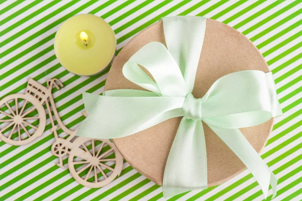 Bougie allumée et boîte cadeau avec ruban vert — Photo