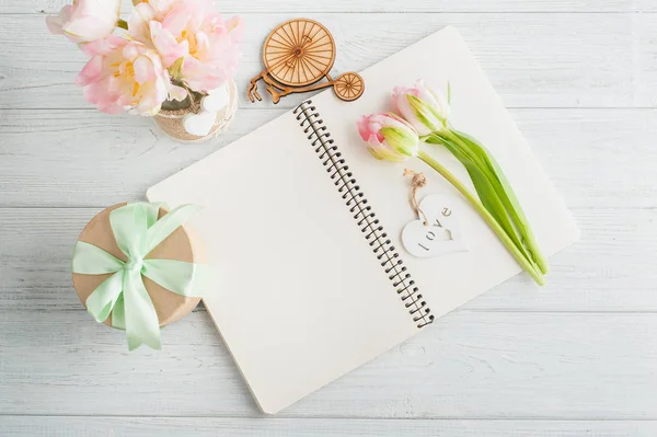 Bouquet of pink tulips and open note book