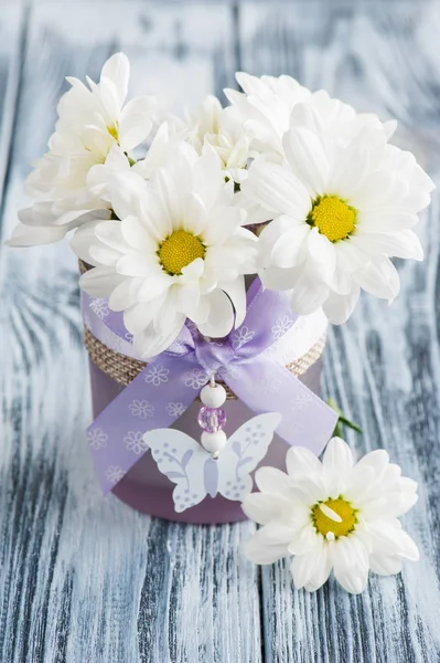 Flores frescas de margarida em vidro roxo — Fotografia de Stock