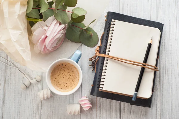 Carnet vierge ouvert, bouquet, tasse de café, écouteurs — Photo