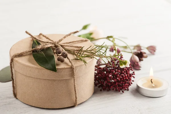 Hand gemaakte gift en verlichte kaars — Stockfoto