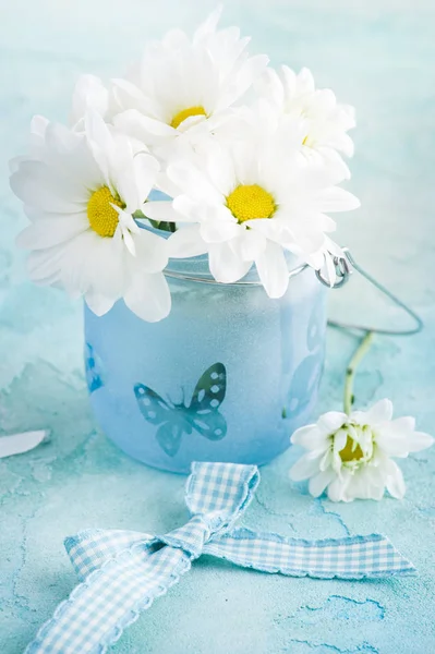 Verse madeliefjebloemen in blauw glas — Stockfoto