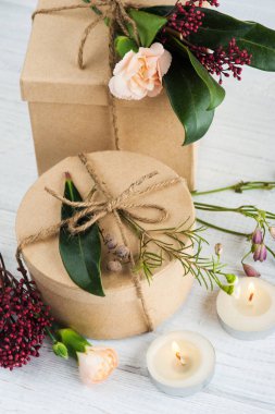 Hediyeler ve yanan mum, çiçek