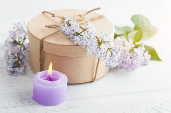 Bougie violette allumée et fleurs lilas — Photo