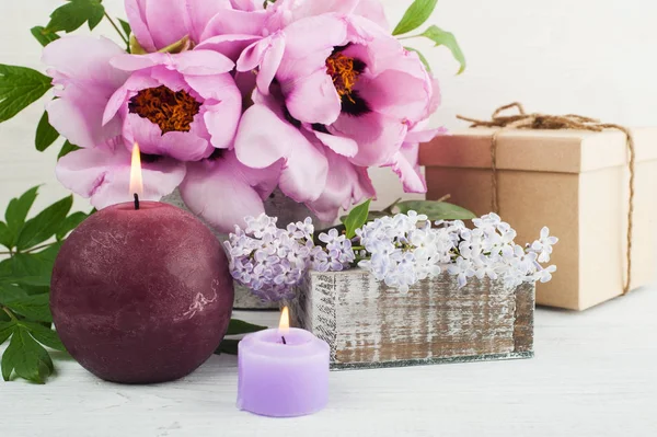 Aangestoken kaarsen, pioenrozen en lila bloemen — Stockfoto