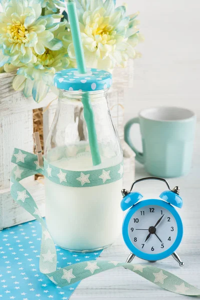 Bottiglia di latte con paglia e sveglia blu — Foto Stock