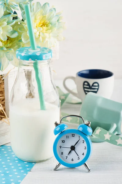 Bottiglia di latte con paglia e sveglia blu — Foto Stock