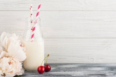 Şişe süt ile kırmızı kiraz