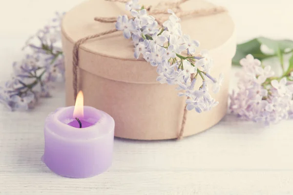 Bougie violette allumée et fleurs lilas — Photo