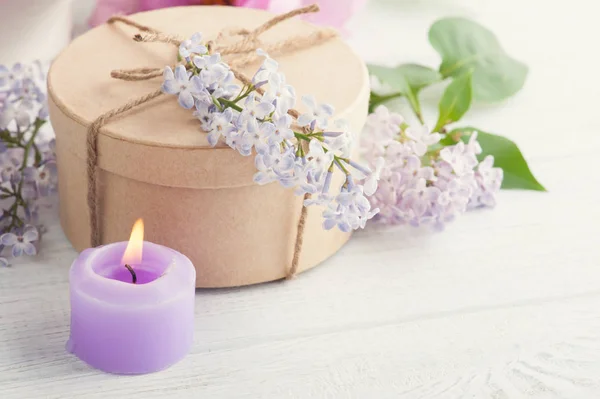 Bougie violette allumée et fleurs lilas — Photo