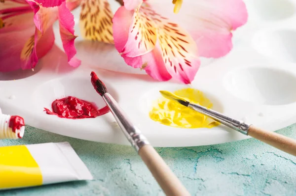 Pincel de pintura, vermelho, tinta aquarela amarela com flores da primavera — Fotografia de Stock