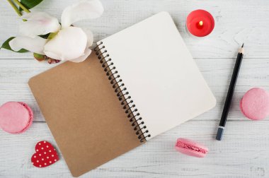 Boş defter, pembe macaroons, mum yaktı