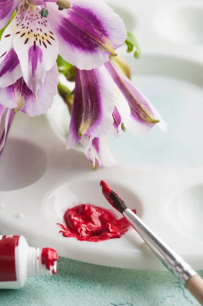 Pincel de pintura, tinta aquarela vermelha com flores da primavera — Fotografia de Stock