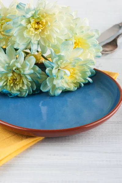 Цветы Хризантемы на тарелке на деревянном столе — стоковое фото