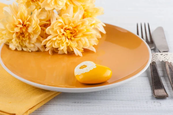 Chrysanthemum flowers on a plate on wooden table — Stock Photo, Image